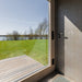 Peaceful lakeside view from inside Geneva St. Moritz sauna with shower room, framed by glass walls and modern timber detailing.