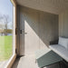 Minimalist interior with full-height wooden door and lounge seating inside Geneva St. Moritz outdoor sauna and shower cabin.