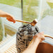 Ladle over HUUM heater inside St. Moritz sauna, framed by stunning lakeside background.