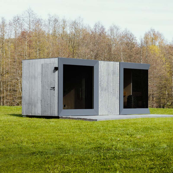 Geneva St. Moritz outdoor sauna cabin with shower room, viewed from the side, featuring modern vertical timber cladding and large glass panels.