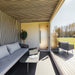 Cosy covered terrace of Geneva St. Moritz outdoor sauna, featuring soft seating, glass wall views, and minimal Nordic-inspired design details.