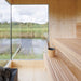 Clean interior corner of the Zermatt sauna with tiered seating, timber walls, and corner glass windows providing stunning outdoor views.
