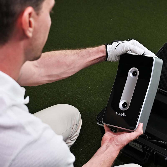 Close-up of a golfer calibrating the Golfjoy GDS Plus Launch Monitor, ensuring accurate data collection and performance measurement.