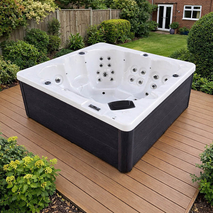 H2O Azure 5-Person Hot Tub on composite decking with jets and fountain feature running, white acrylic shell, dark cabinet and UK garden backdrop