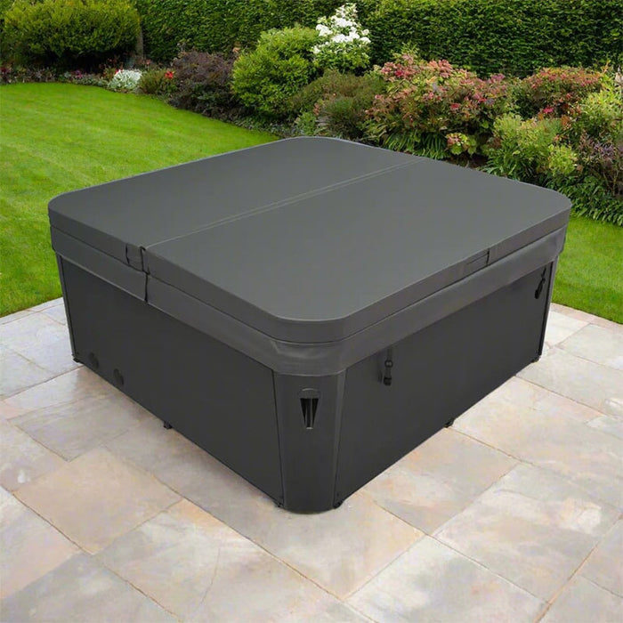 H2O Coral 5-Person Hot Tub with grey insulated cover closed, installed on a stone patio in a landscaped UK garden