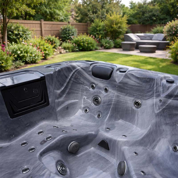 H2O Retreat Pro 5-Person Hot Tub grey marbled acrylic interior with stainless steel jets and integrated touchscreen panel, set in a landscaped UK garden