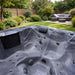 H2O Retreat Pro 5-Person Hot Tub grey marbled acrylic interior with stainless steel jets and integrated touchscreen panel, set in a landscaped UK garden