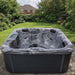 H2O Retreat Pro 5-Person Hot Tub with dark grey marbled shell and charcoal cabinet installed on a stone patio in a UK garden