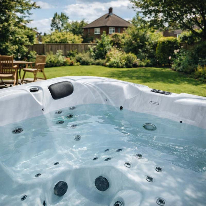 H2O Retreat Pro 5-Person Hot Tub white interior filled with water showing jet layout and seating positions, installed in a sunny UK garden