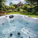 H2O Retreat Pro 5-Person Hot Tub white interior filled with water showing jet layout and seating positions, installed in a sunny UK garden