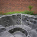H2O Vortex 6-Person Hot Tub grey marbled interior showing stainless steel jet arrangement and footwell speaker positions against a brick wall backdrop