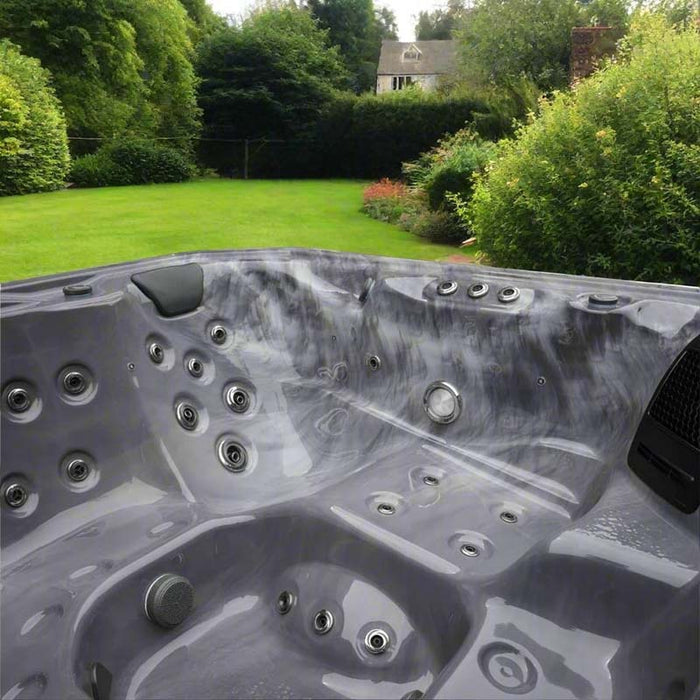 H2O Vortex 6-Person Hot Tub grey marbled acrylic interior showing full jet layout and contoured seating with UK garden backdrop