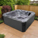 H2O Vortex 6-Person Hot Tub with grey marbled shell and charcoal cabinet shown from an angled view on a sandstone patio with timber fence backdrop