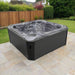 H2O Vortex 6-Person Hot Tub with grey marbled shell and charcoal cabinet installed on a stone patio in a fenced UK garden