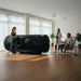 Active wellness consultation with the Henshaw 1662 Hyperbaric Oxygen Chamber, fitness client, and professionals in a bright modern clinic.