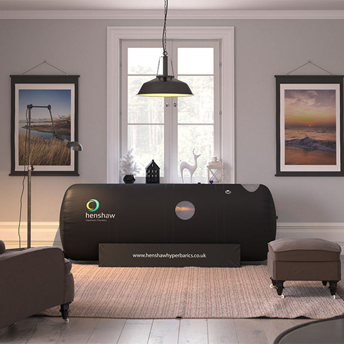 Henshaw 1662 Hyperbaric Oxygen Chamber elegantly placed in a cosy, art-filled home therapy room with a calm and inviting atmosphere.