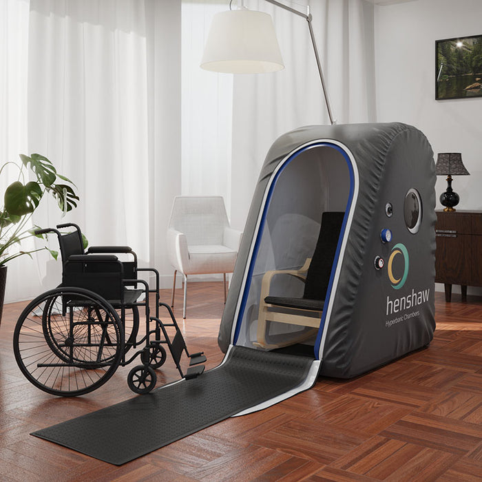 Henshaw Easy Access Hyperbaric Oxygen Chamber with extended ramp and interior chair in a stylish therapy room, showing accessibility features.