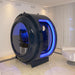 Henshaw Monozen Hyperbaric Oxygen Chamber in an ambient clinical lounge, lit by soft blue LED lighting and designed for seated comfort and immersive therapy.