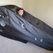 Man inside a Henshaw Recline Hyperbaric Oxygen Chamber using an oxygen mask for wellness and recovery therapy at home.