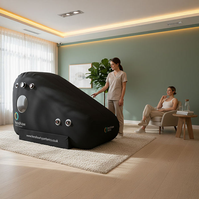 Practitioner assisting a client with the Henshaw Recline Hyperbaric Chamber during a wellness therapy session in a spa setting.