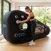 Active woman operating the Henshaw Recline XL Sport Hyperbaric Chamber while another user relaxes inside during therapy.