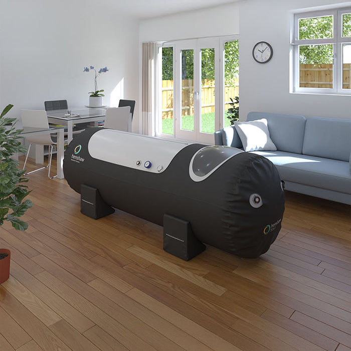 Henshaw Solo Hyperbaric Oxygen Chamber in a cosy residential living space with wooden flooring, dining area, and bright natural light.