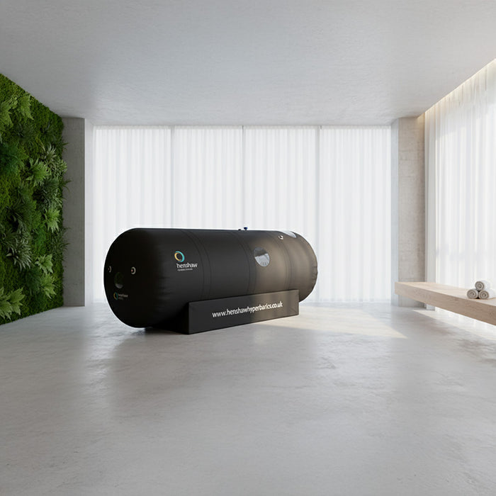 Henshaw Space Hyperbaric Oxygen Chamber in a calming wellness room with natural lighting and vertical garden, ideal for restorative therapy.