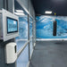 Hypoxico Full Climate Hypoxic Chamber interior with curved treadmill handrail in foreground and branded black entry door with observation window in background.