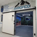 Hypoxico Full Climate Hypoxic Chamber room entry with large insulated sliding door, branded signage above, and mountain landscape mural visible inside.