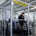 Hypoxico Hypoxic Altitude Chamber with yellow high altitude room signage reading Train at 9000 Feet, athlete using treadmill inside clear acrylic pod in commercial gym.