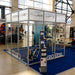 Hypoxico Hypoxic Altitude Chamber large walk-in enclosure with aluminium frame and clear panels in a public leisure centre, elliptical trainer inside and hypoxic generator unit alongside.