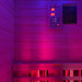 The Insignia KY001 Infrared Indoor Sauna glowing in pink and blue LED lighting, highlighting the sauna’s modern light therapy features.