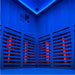 Interior view of the Insignia KY006 Infrared Indoor Sauna 1300 x 1300mm with glowing red carbon heaters and blue chromotherapy ceiling lights.