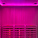 Interior of the Insignia KY006 Infrared Indoor Sauna illuminated in soothing pink LED Chromotherapy lighting, highlighting the spacious and comfortable seating.