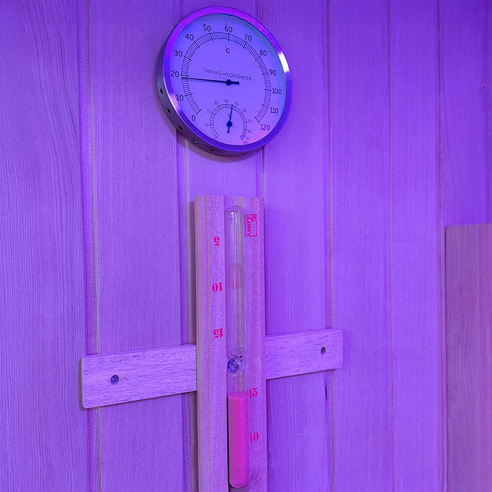 Interior view of the Insignia KY2216 Sauna showing the built-in thermometer and sand timer for monitoring temperature and session duration.