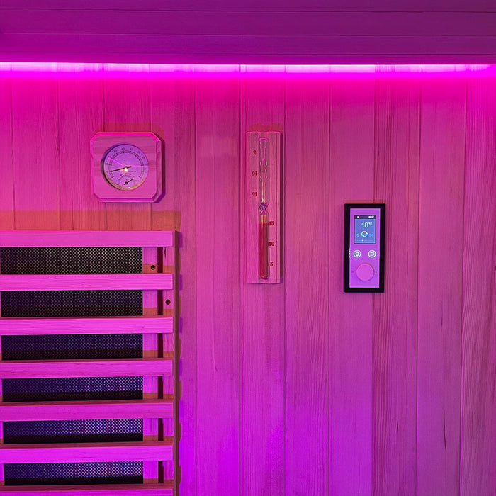 The interior wall of the Insignia Outdoor Hybrid Infrared Sauna 1700 x 1500mm, featuring the digital control panel and a wooden thermometer, with soothing pink LED Chromotherapy lighting illuminating the space.