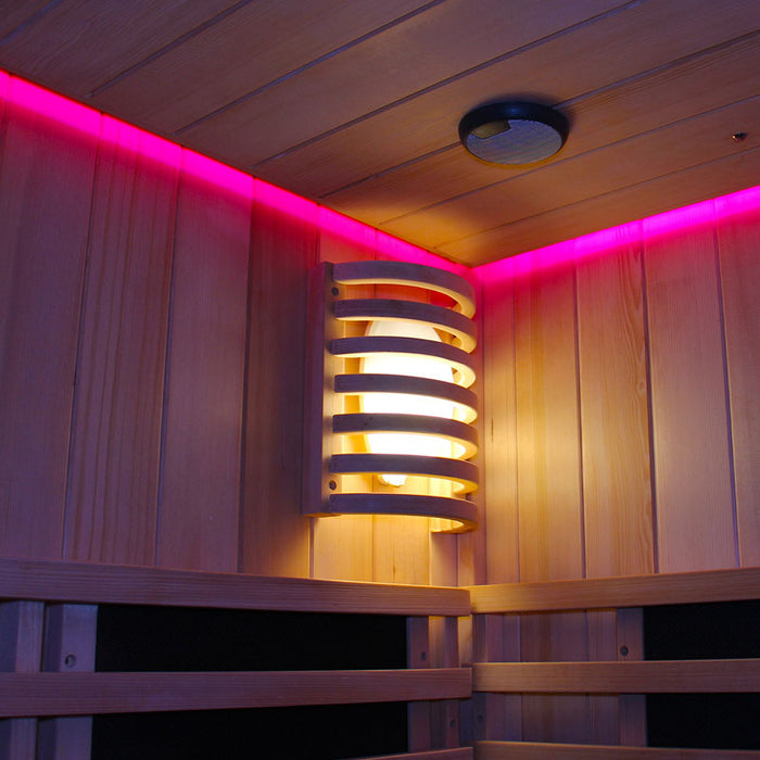 Interior of the Insignia Outdoor Hybrid Infrared Sauna 2000 x 2000mm, showing wooden wall lamp and pink LED Chromotherapy lighting for enhanced relaxation.