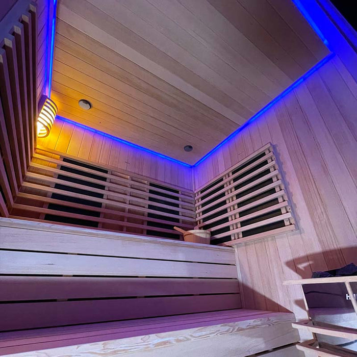 The Insignia Outdoor Hybrid Infrared Sauna 2000 x 2000mm illuminated with calming blue LED Chromotherapy lights, creating a relaxing and luxurious atmosphere.