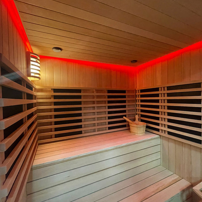 Interior of the Insignia Outdoor Hybrid Infrared Sauna 2000 x 2000mm, featuring red LED Chromotherapy lighting and wooden benches for a soothing sauna experience.