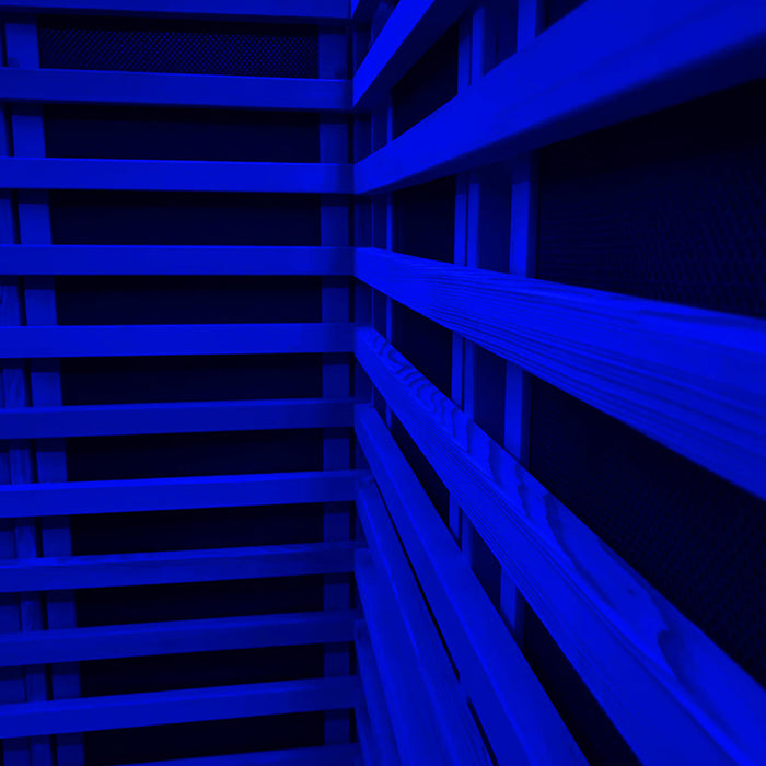 A detailed view of the wooden slats and heater panels illuminated by calming blue chromotherapy lighting inside the Insignia Outdoor Infrared Sauna 1500 x 1300mm.