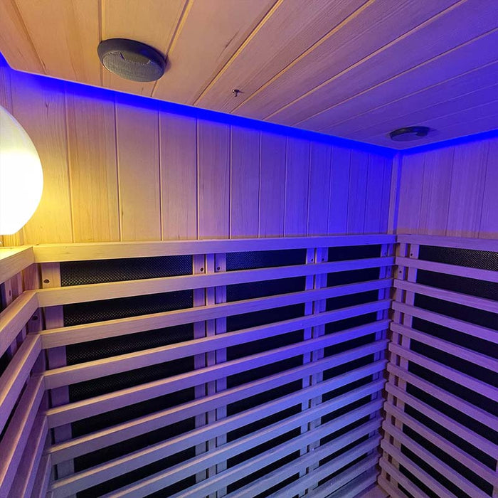 A serene interior of the Insignia Outdoor Infrared Sauna 1500 x 1300mm bathed in blue chromotherapy lighting, featuring the elegant wooden slats and sleek heater panels.