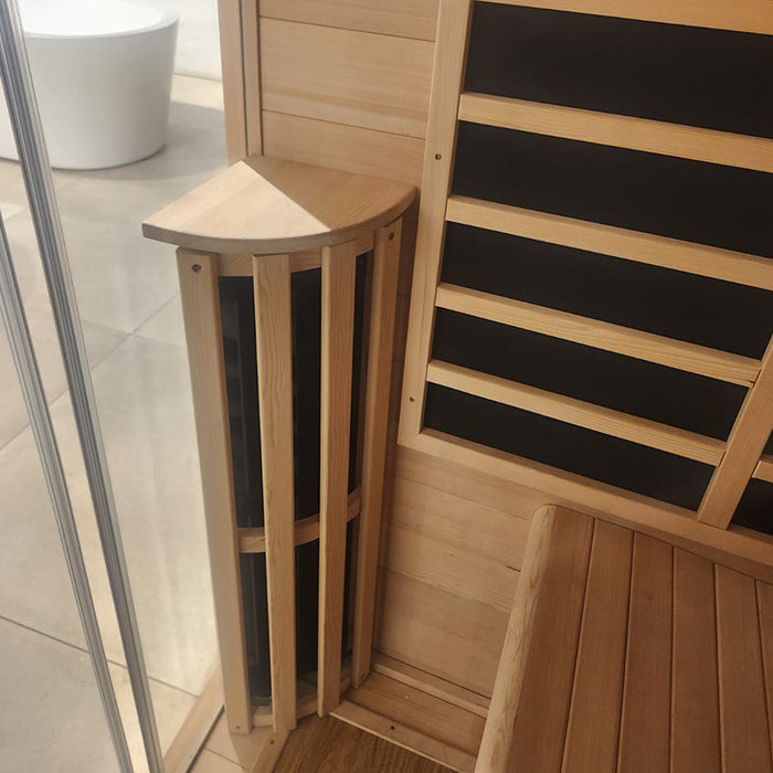 Close-up of the corner carbon heater and wooden bench inside the Jaquar infrared sauna, showcasing the fine Hemlock wood craftsmanship.