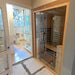 Jaquar infrared sauna installed in a contemporary home bathroom, showcasing its seamless glass door and compact wooden frame.