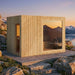 Scenic Jonas Classic 4–6 person sauna cabin with light wood finish overlooking mountain lake at sunset – premium outdoor relaxation experience.