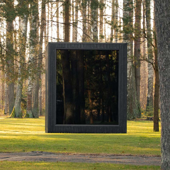 Front view of the Jonas Classic 4-person outdoor sauna in woodland clearing, featuring large mirrored glass façade.