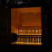 Illuminated Jonas Classic 4-person outdoor sauna glowing at night with warm ambient lighting, showcasing its premium timber interior and modern glass front.