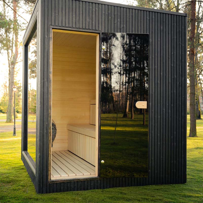 Daytime view of the Jonas Classic 4-person outdoor sauna in garden setting, showing open glass door and light wood interior.