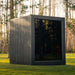 Rear angle view of the Jonas Classic outdoor sauna with sleek black timber cladding and large mirrored glass panel.