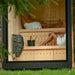 Two people enjoying the warm interior of the Jonas Classic sauna, seated on upper and lower wooden benches with a HUUM heater beside them.