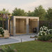 Spacious Jonas Grand 8–10 person outdoor lounge sauna set in a landscaped garden with timber chairs, blooming flowers, and a modern pergola – ideal for luxury wellness retreats.